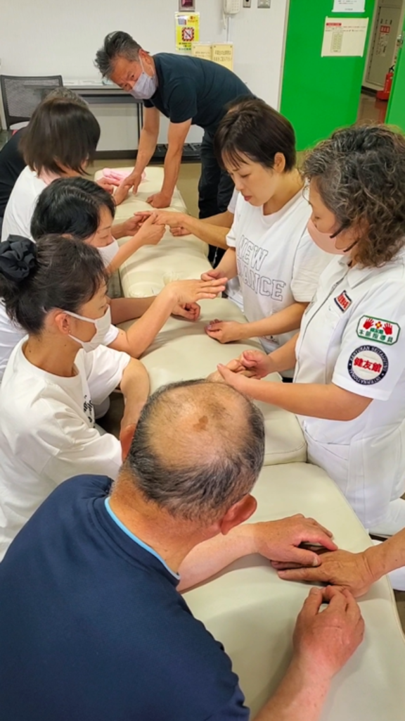 健友館整体師養成所の東京都での出張実技講習会で手技をマンツーマン指導する様子