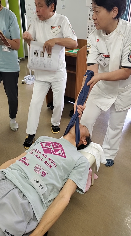 健友館整体師養成所の東京都での出張実技講習会で整体用器具のマンツーマン指導する様子