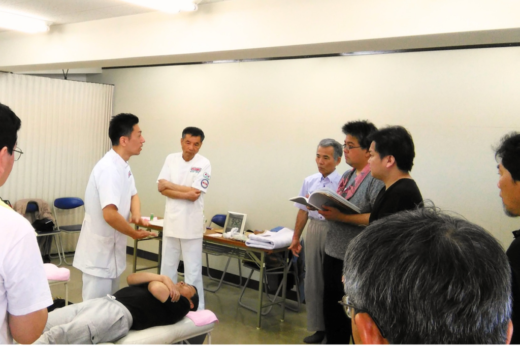 健友館整体師養成所の実技講習会で受講生に整体技術を指導している様子