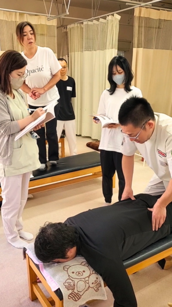 健友館整体師養成所で講師が受講生に整体技術をマンツーマン指導する様子